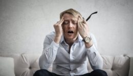 photo of man touching his head